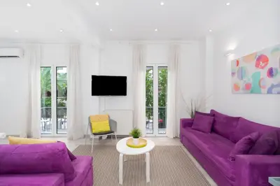 a living room with purple couches and a tv at Spacious Modern Apartment in Athens near Metro in Athens