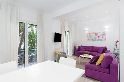 a living room with a purple couch and a table at Spacious Modern Apartment in Athens near Metro in Athens