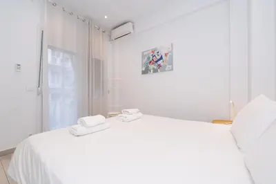 a white bedroom with a white bed and a window at Spacious Modern Apartment in Athens near Metro in Athens