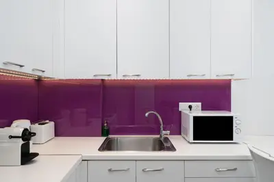 a kitchen with a sink and a purple wall at Spacious Modern Apartment in Athens near Metro in Athens