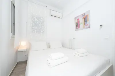 a white bedroom with a white bed and a window at Spacious Modern Apartment in Athens near Metro in Athens
