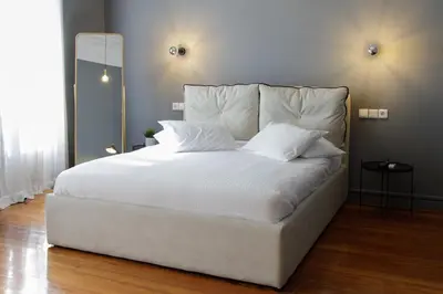 a large bed with white sheets and pillows at Soho Apartments in Athens