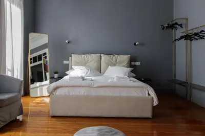 a bedroom with a large white bed and a mirror at Soho Apartments in Athens