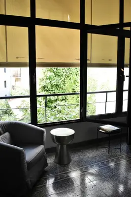 a living room with large windows and a couch at Soho Apartments in Athens