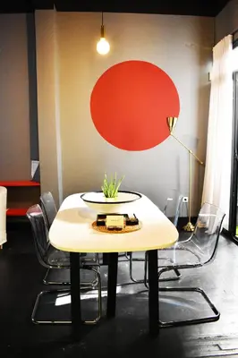 a table with chairs and a red circle on the wall at Soho Apartments in Athens
