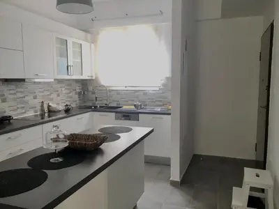 a kitchen with white cabinets and a counter at Adrianou 150 in Athens