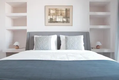 a bedroom with a large bed with blue and white pillows at Athens Grand Suite in Athens