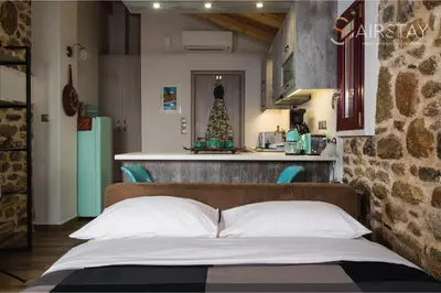 a bedroom with a bed and a kitchen with a christmas tree at Orianna Apartment Airport by Airstay in Spáta