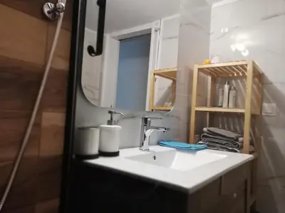 a bathroom with a sink and a mirror at Fotini's place! in Athens
