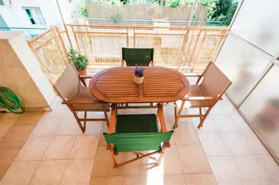 a wooden table and chairs with a plant on it at Fotini's place! in Athens