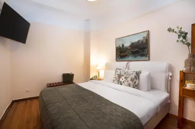 a bedroom with a large white bed and a television at Art Gallery Hotel in Athens