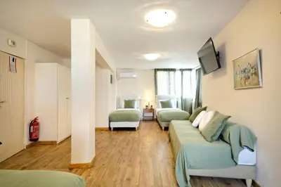 a room with a couch and a bed and a tv at Art Gallery Hotel in Athens