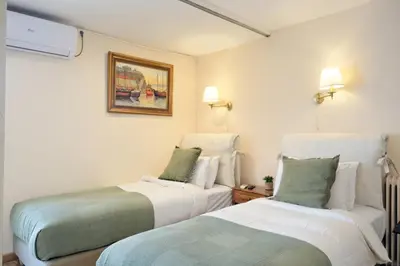 a room with two beds and a painting on the wall at Art Gallery Hotel in Athens