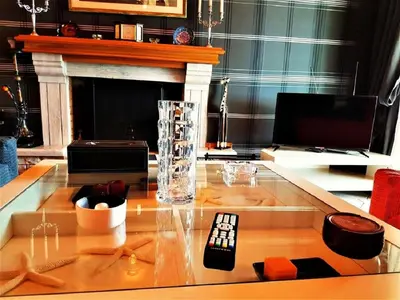 a living room with a glass table with a remote control at Villa 