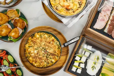 a table topped with plates of food and pies at Gaia Athens in Athens
