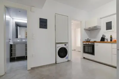 a white kitchen with a washing machine in it at Athens One Apartment by Olala Homes in Athens