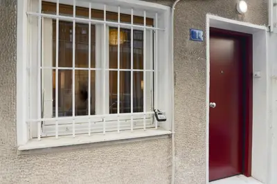 a window on the side of a building with a red door at Athens One Apartment by Olala Homes in Athens