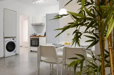 a white kitchen with a white table and chairs at Athens One Apartment by Olala Homes in Athens