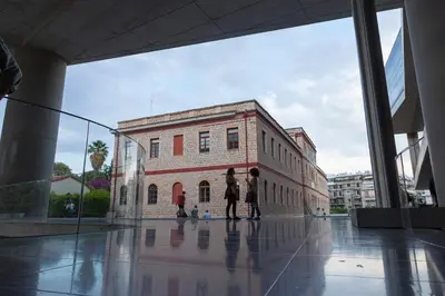 two people standing in front of a brick building at Your home @Acropolis Museum in Athens