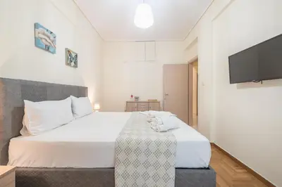 a bedroom with a bed and a flat screen tv at Elegant Home in Quiet Street by Cloudkeys in Athens