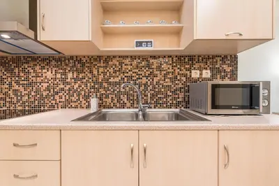 a kitchen with a sink and a microwave at Elegant Home in Quiet Street by Cloudkeys in Athens