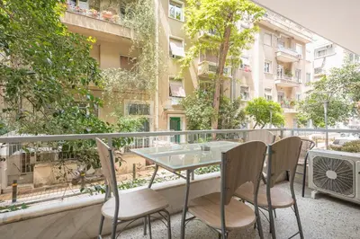 a table and chairs on the balcony of a building at Elegant Home in Quiet Street by Cloudkeys in Athens