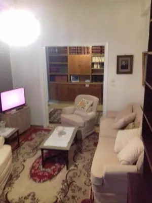 a living room with a couch and chairs and a tv at George apartment in Athens