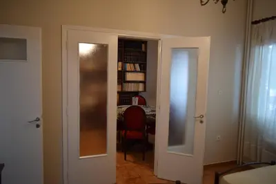 a hallway with two doors and a room with a table at George apartment in Athens