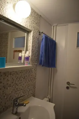 a bathroom with a sink and a mirror and blue towel at George apartment in Athens