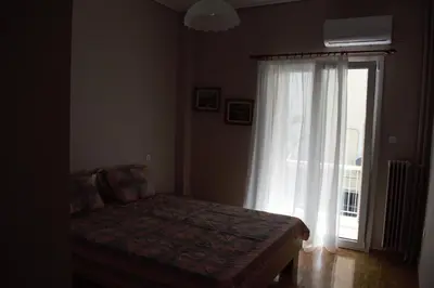 a bedroom with a bed and a large window at George apartment in Athens