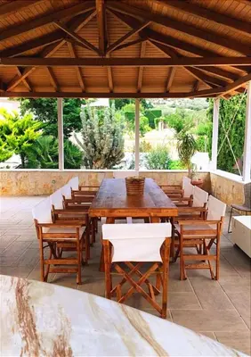 a wooden table and chairs on a patio at Summer Villa Lagonissi in Lagonissi