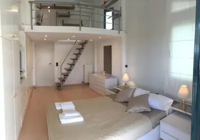 a bedroom with a large bed and a staircase at Summer Villa Lagonissi in Lagonissi