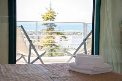 a room with a bed and a view of a balcony at Summer Villa Lagonissi in Lagonissi