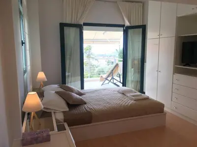 a bedroom with a bed and a large window at Summer Villa Lagonissi in Lagonissi