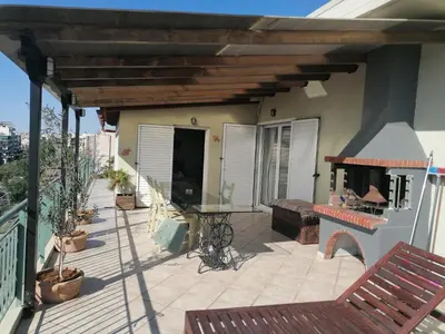 a patio with a table and a fireplace on a house at Center gazi historical in Athens