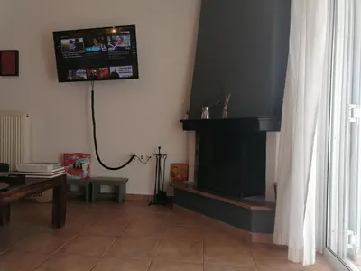 a living room with a fireplace and a tv on the wall at Center gazi historical in Athens