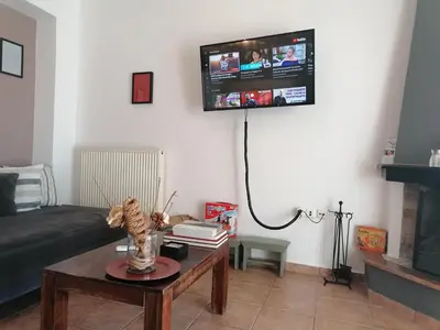 a living room with a couch and a tv on the wall at Center gazi historical in Athens