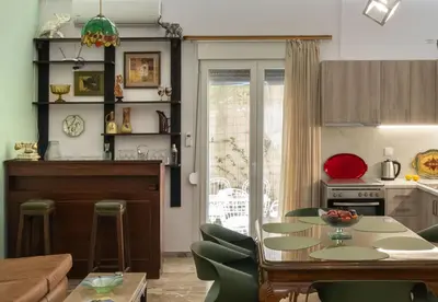 a kitchen and living room with a table and chairs at Acropolis Koukaki Loft Private Garden in Athens