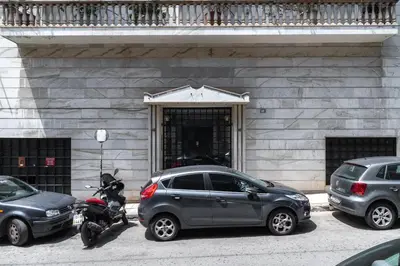 a car and a motorcycle parked in front of a building at Acropolis Koukaki Loft Private Garden in Athens