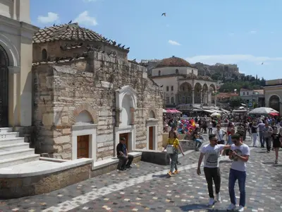 a crowd of people walking around a building at Monastiraki flea market & metro station appartment in Athens