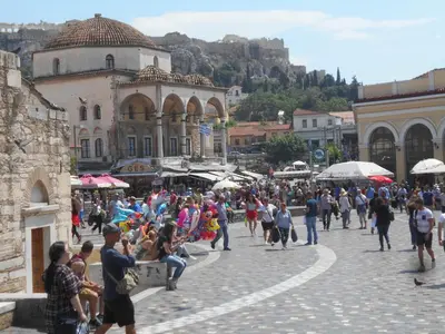 a crowd of people walking down a city street at Monastiraki flea market & metro station appartment in Athens