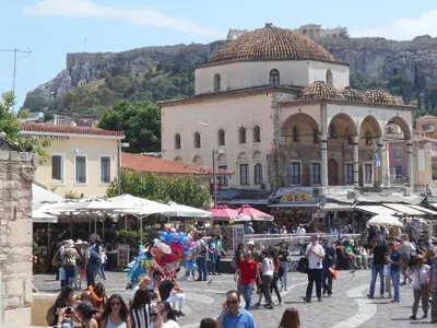 a crowd of people walking around a market in front of a building at Monastiraki flea market & metro station appartment in Athens