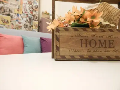 a wooden sign sitting on top of a table with flowers at Feels Like Home 1 in Athens