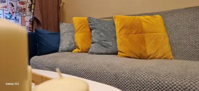 a couch with yellow and blue pillows on it at Feels Like Home 1 in Athens