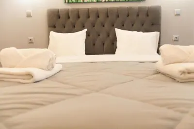 a large bed with white blankets and pillows on it at Athens City Themis 2 in Athens