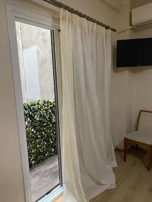 a window with a white curtain next to a window at Athens central apartment in Athens