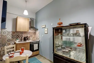 a kitchen with a table and a counter with dishes at Victoria Jewels in Athens