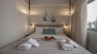 a bed with towels and a plate of fruit on it at Ermou Stylish Suites by GHH in Athens