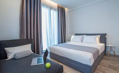 a hotel room with a bed and a laptop on a couch at Spot Apart in Athens