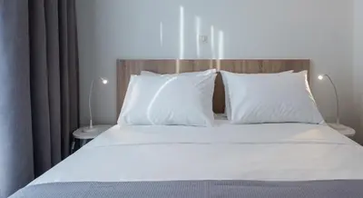 a bedroom with a bed with white sheets and pillows at Spot Apart in Athens